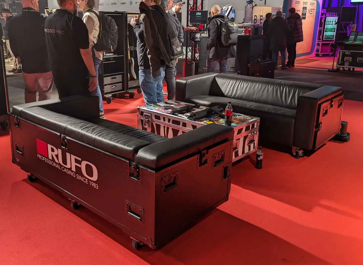 RUFO sofa-flightcase på rød messehall med besøkende i bakgrunnen